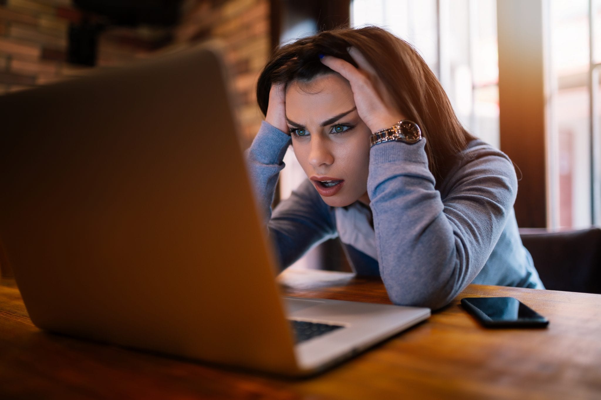 girl freaked out staring at computer screen