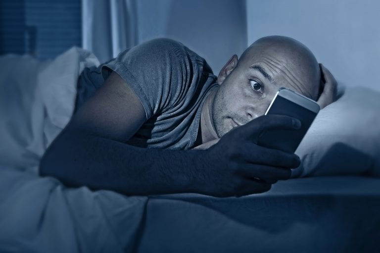 man at night staring at phone