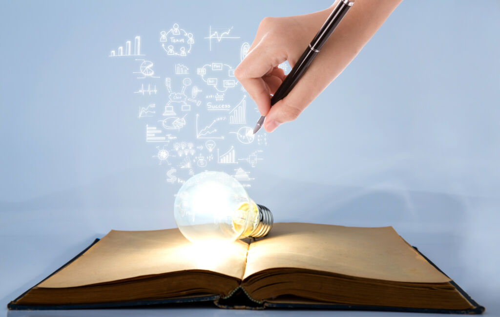 Book and light bulb with hand drawing graph