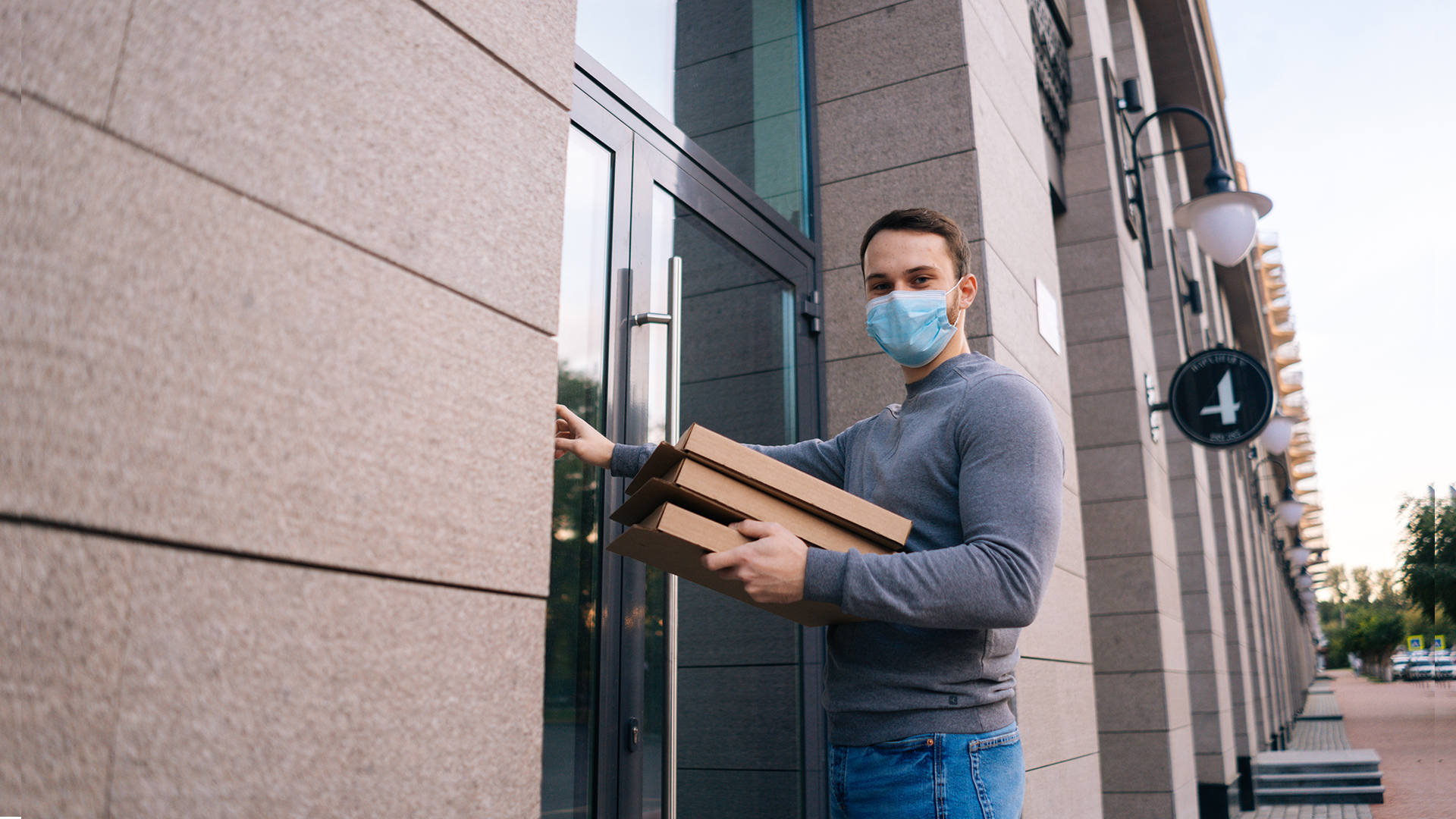feature-delivery-man-wearing-medical-mask-ringing-door-delivery-carton-boxes-with-hot-pizza-copy.jpg