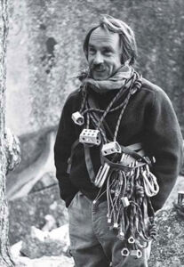 Yvon Chouinard up in the mountains with climbing gear around his neck.