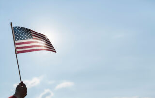 American flag waving against a blue sky