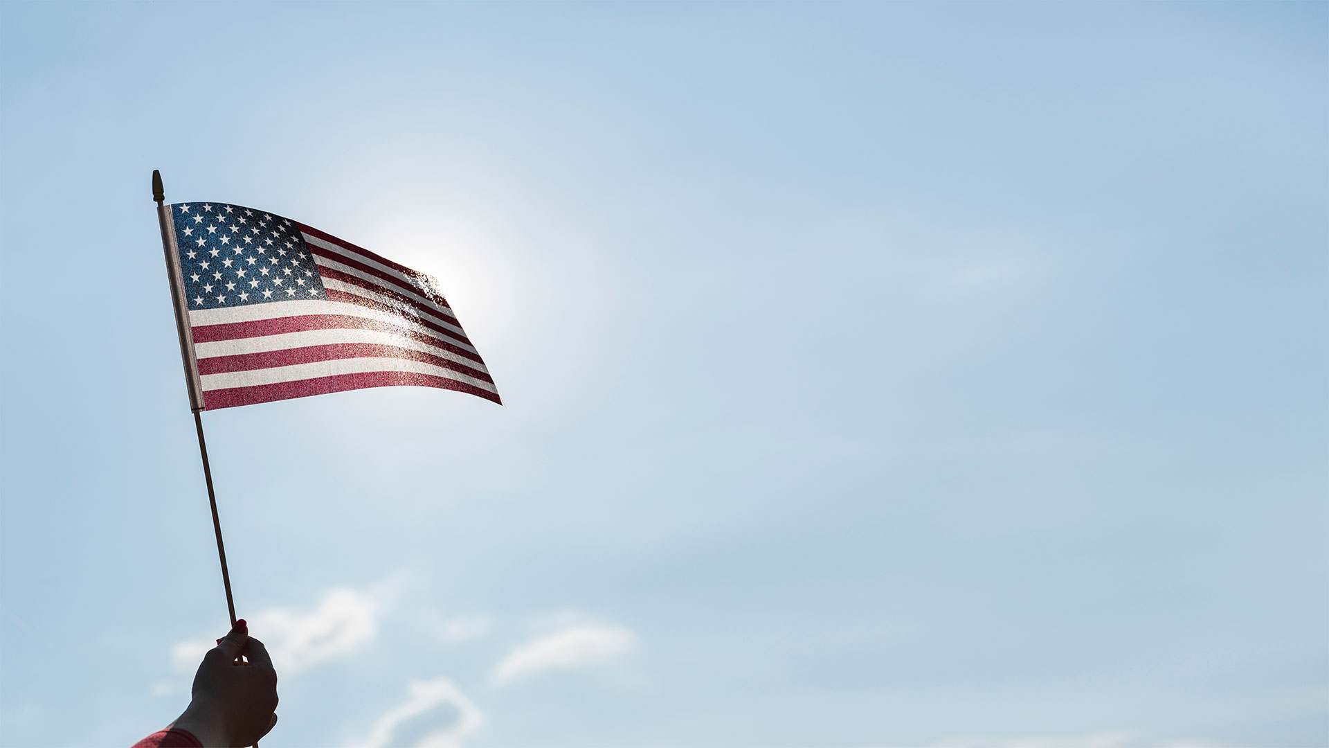 American flag waving against a blue sky
