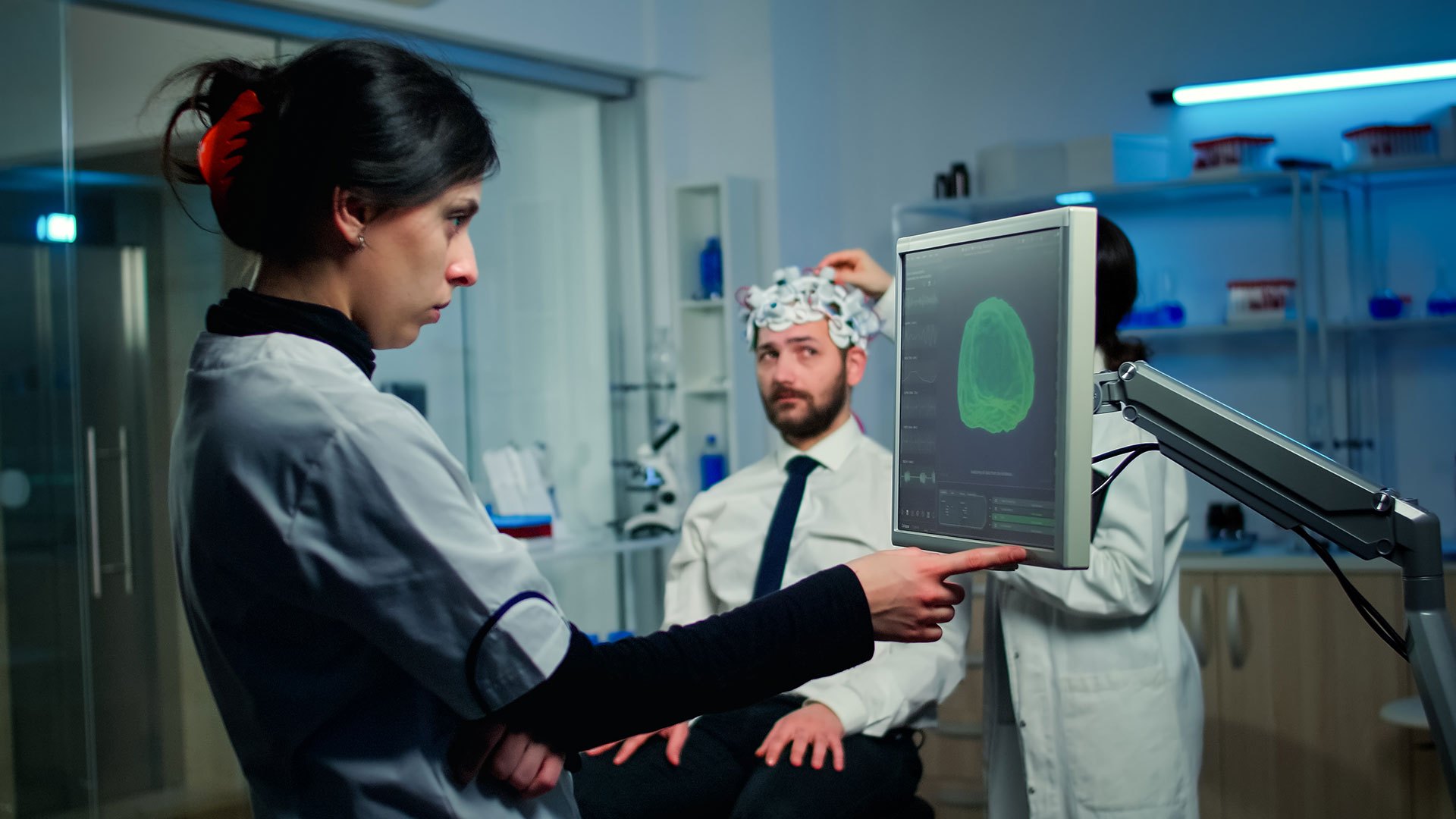 Female doctor looking at brain scan on computer.