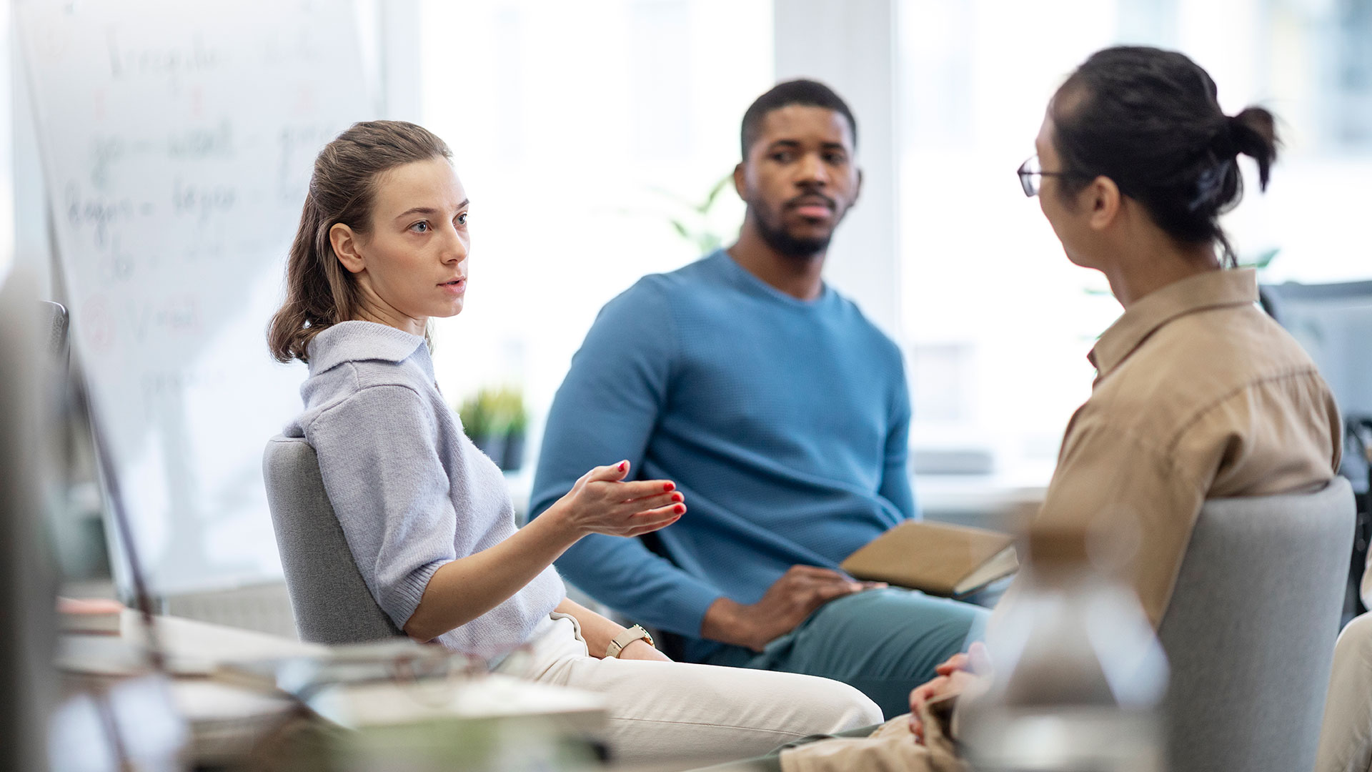 Woman in sitting group gestures and speaks.