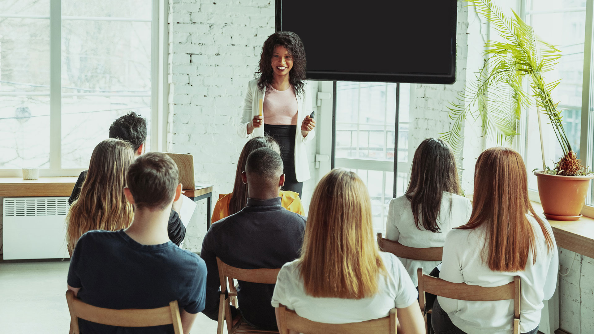 Black female leader talks to a group in an office setting