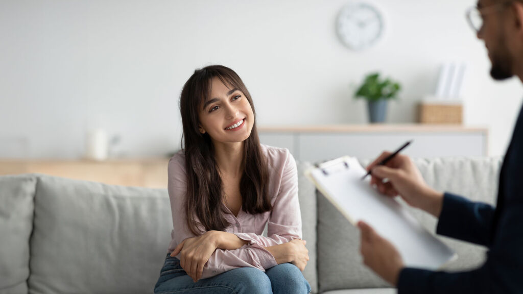 Female patient smiling in psych session.