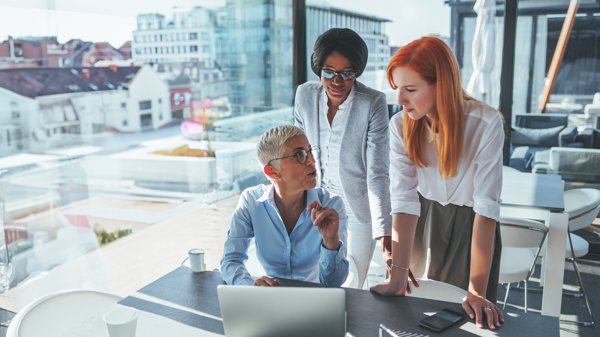 Three women discuss work.