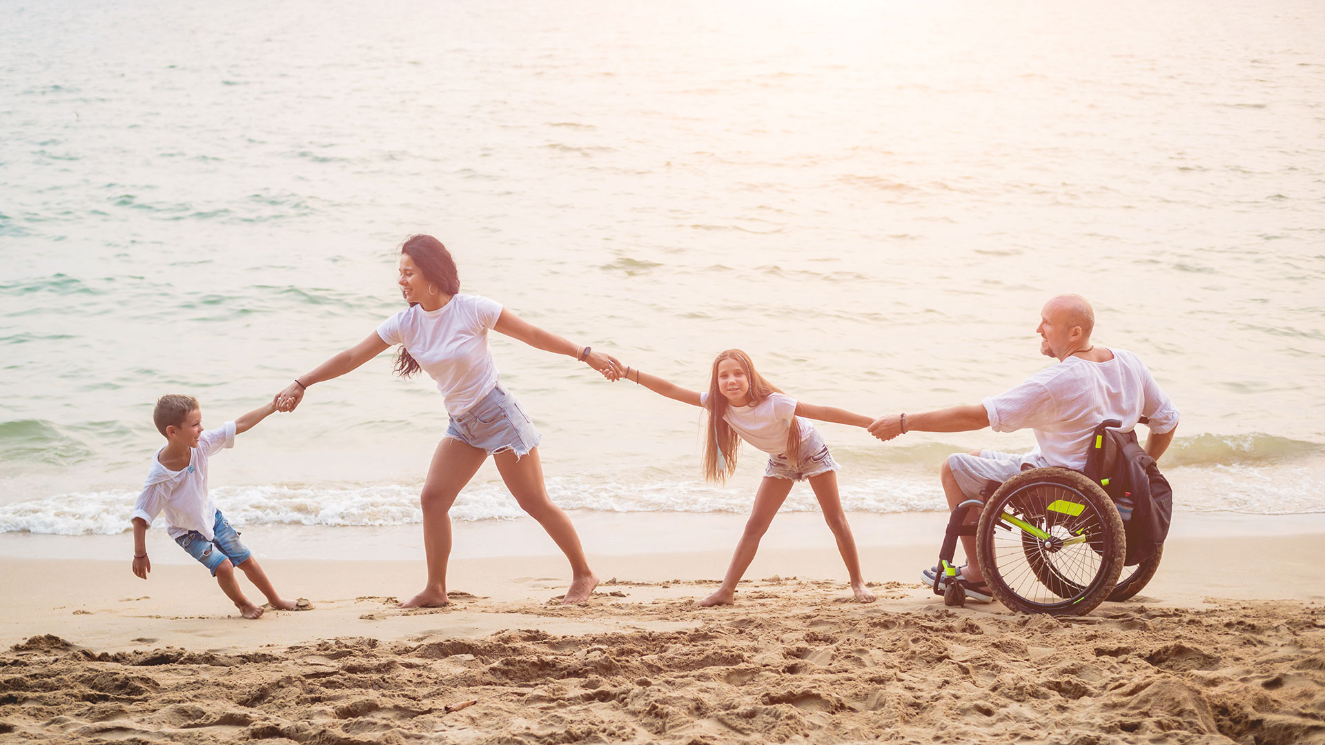 Family walking and holding hands at the beach.