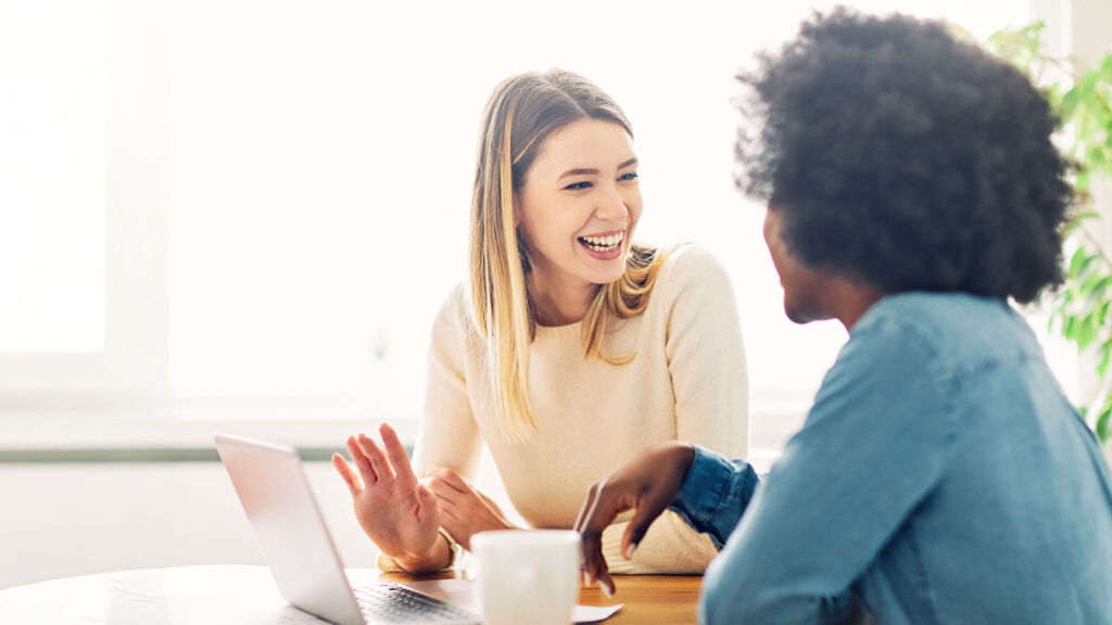 Young business women talk over coffee in the office.