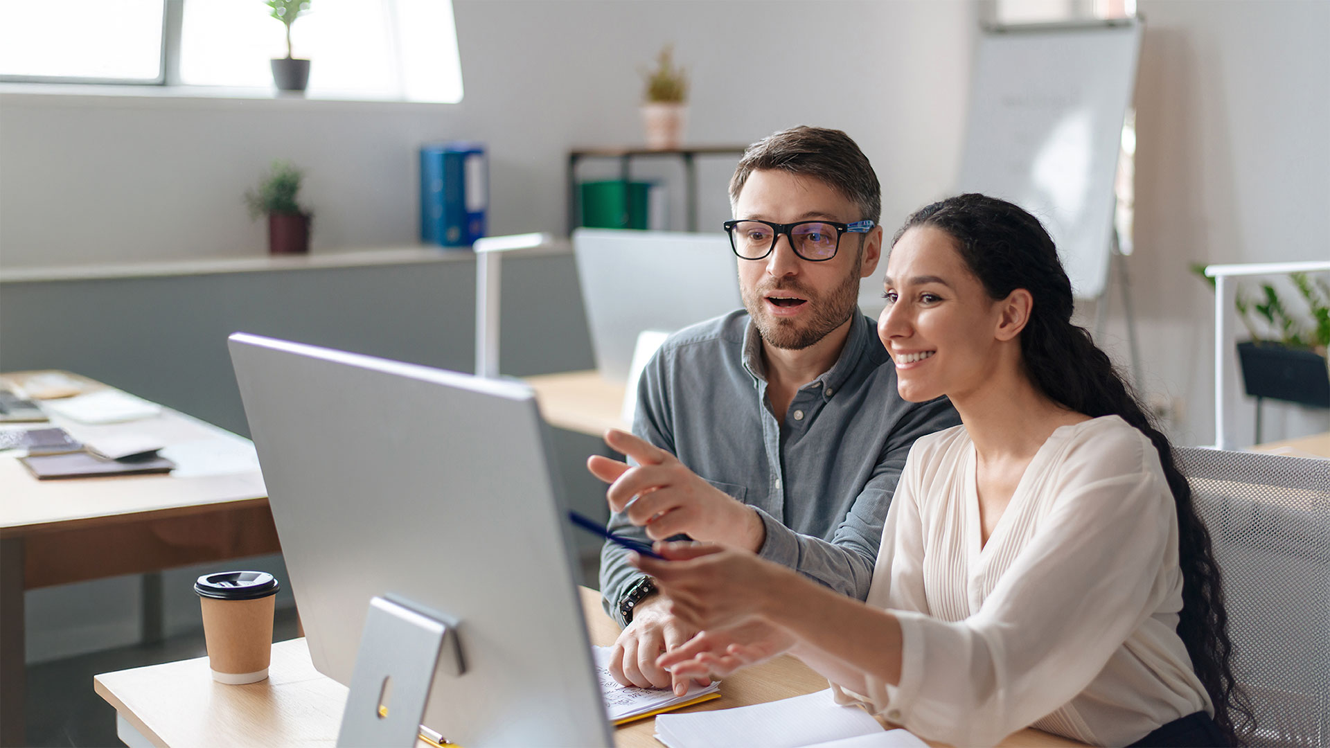 Positive coworkers in front of computer screen